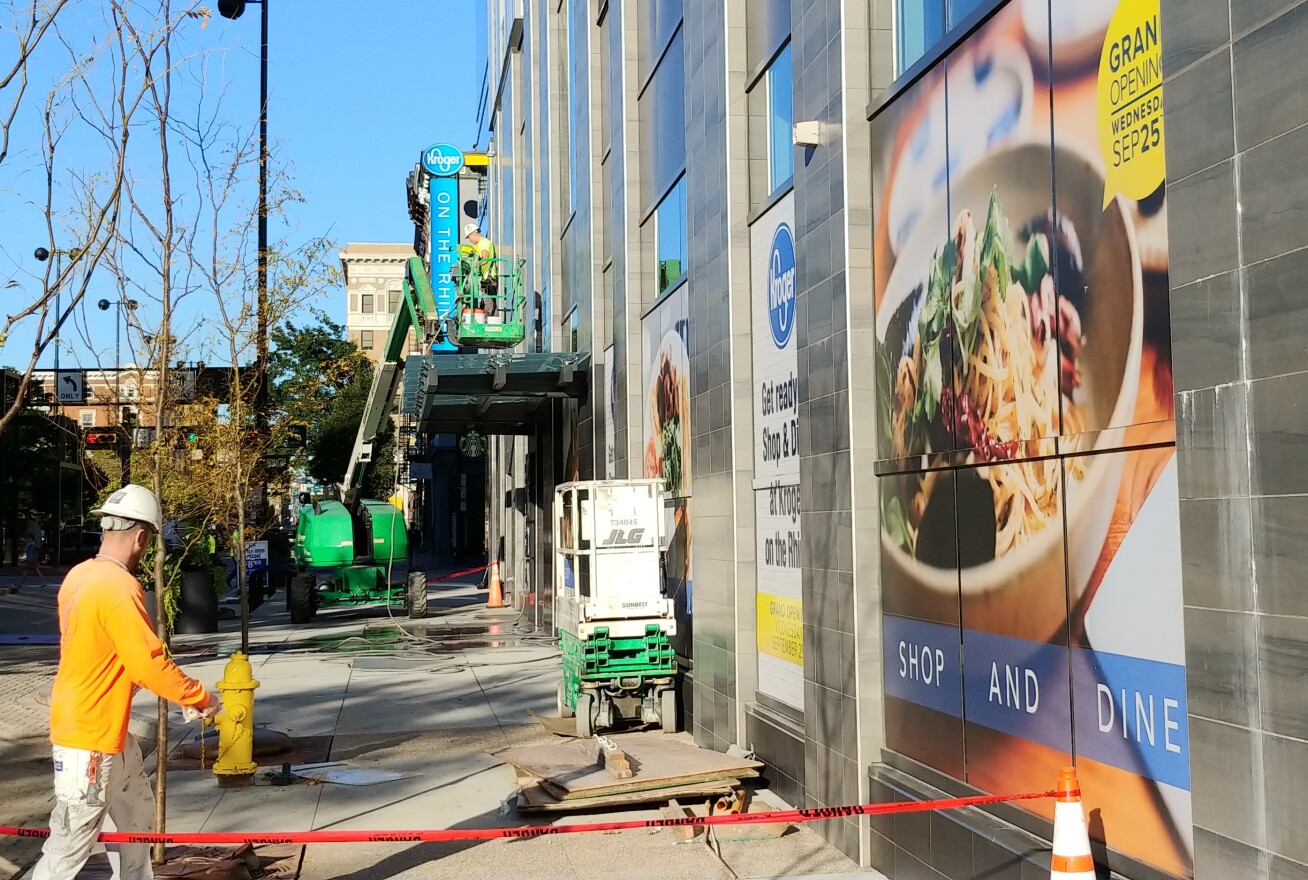 Workers clean up the outside of the new Kroger store, Tuesday morning.